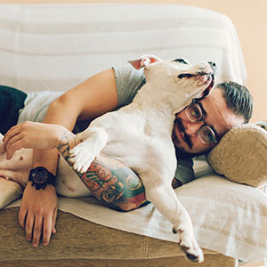 Man-with-tattoo-embracing-his-dog_300x300